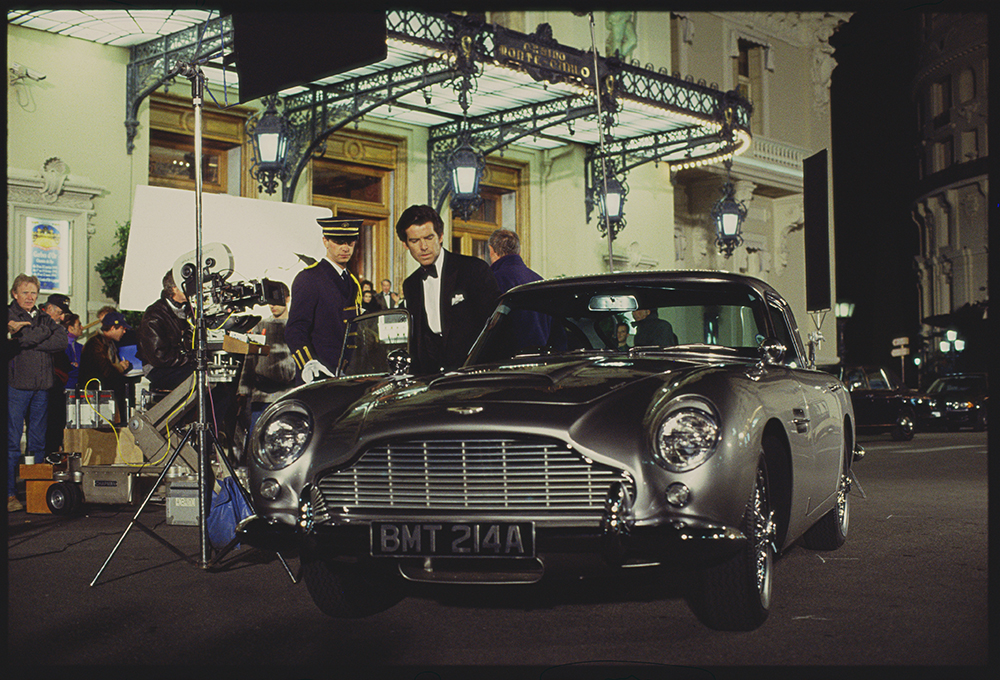 Actor Pierce Brosnan, one of several James Bond actors, hopping into an Aston Martin on set in Monaco.